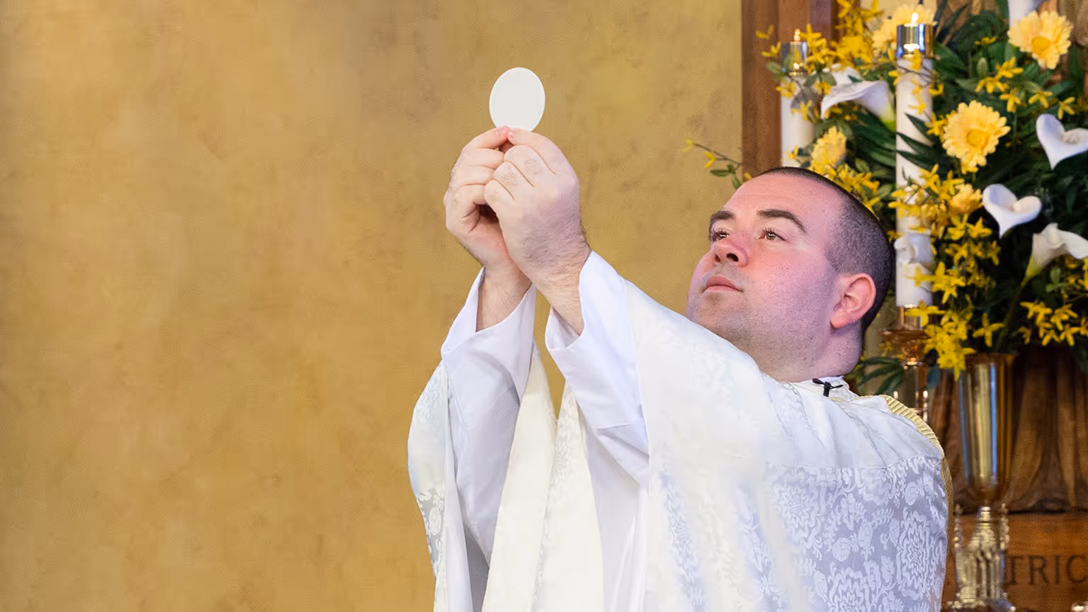 CatholicTV Mass, priest holding up the blessed Eucharist