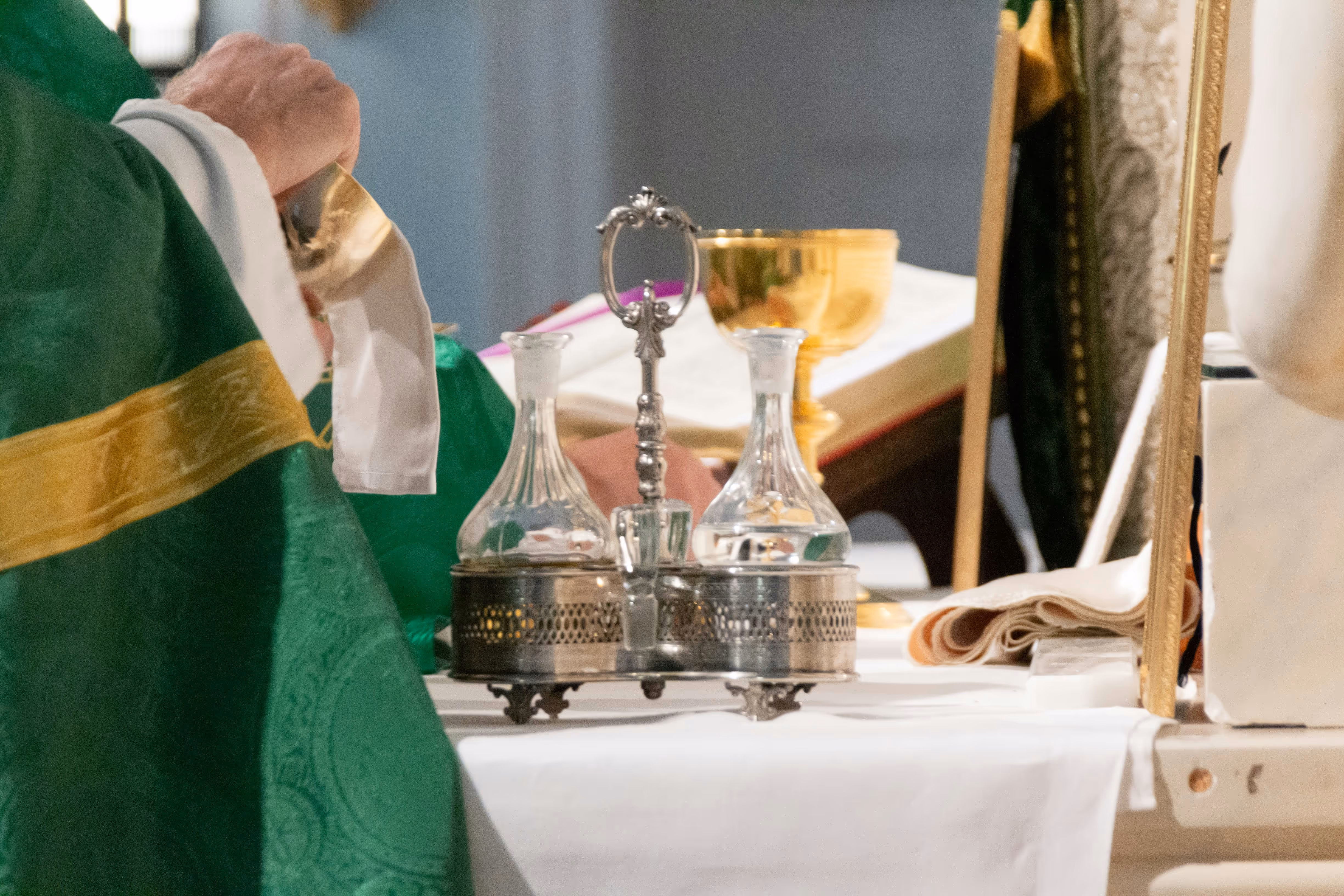 Catholic priest cleaning the sacred vessels on the altar during Mass
