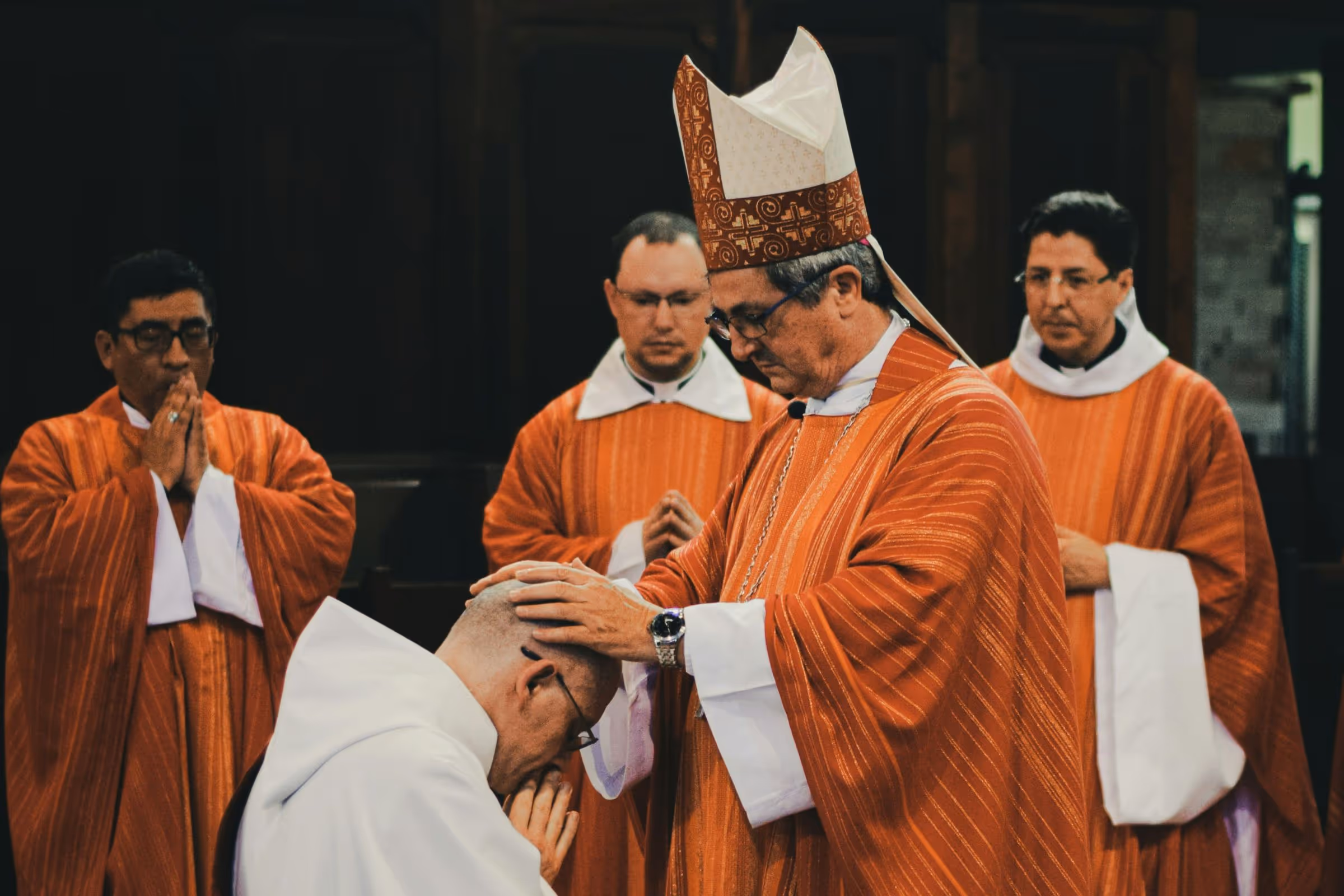 Catholic bishop conferring holy orders on a newly ordained priest