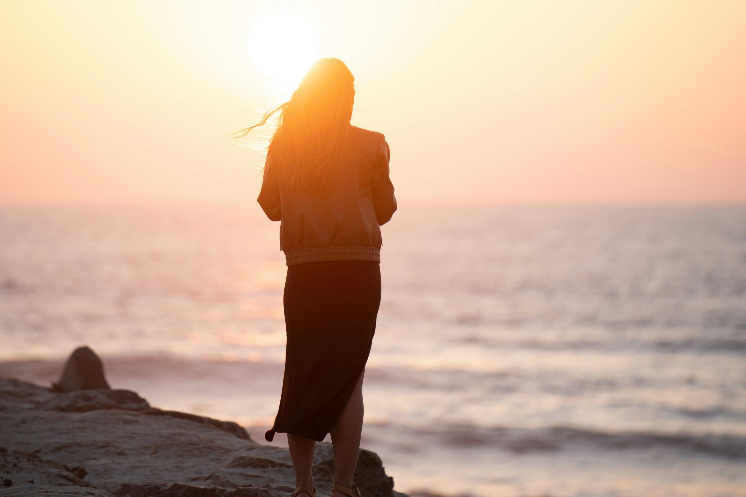 Silhouette of a person standing by the seashore