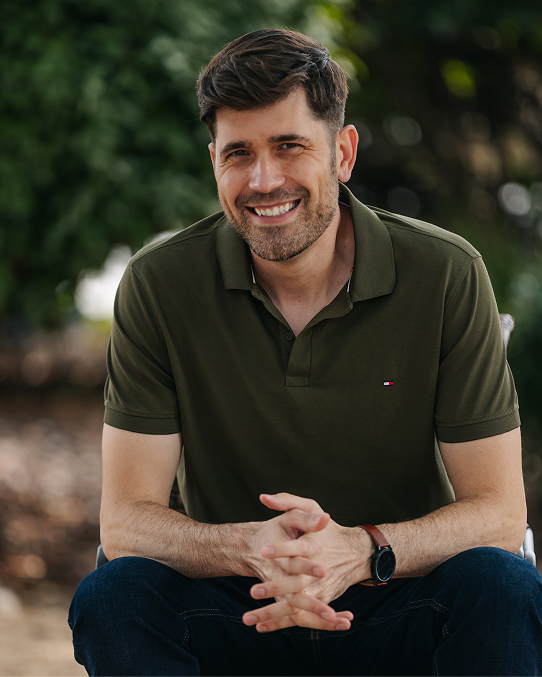 A profile photo of licensed therapist Daniel Nemeth, smiling outside in a park. 