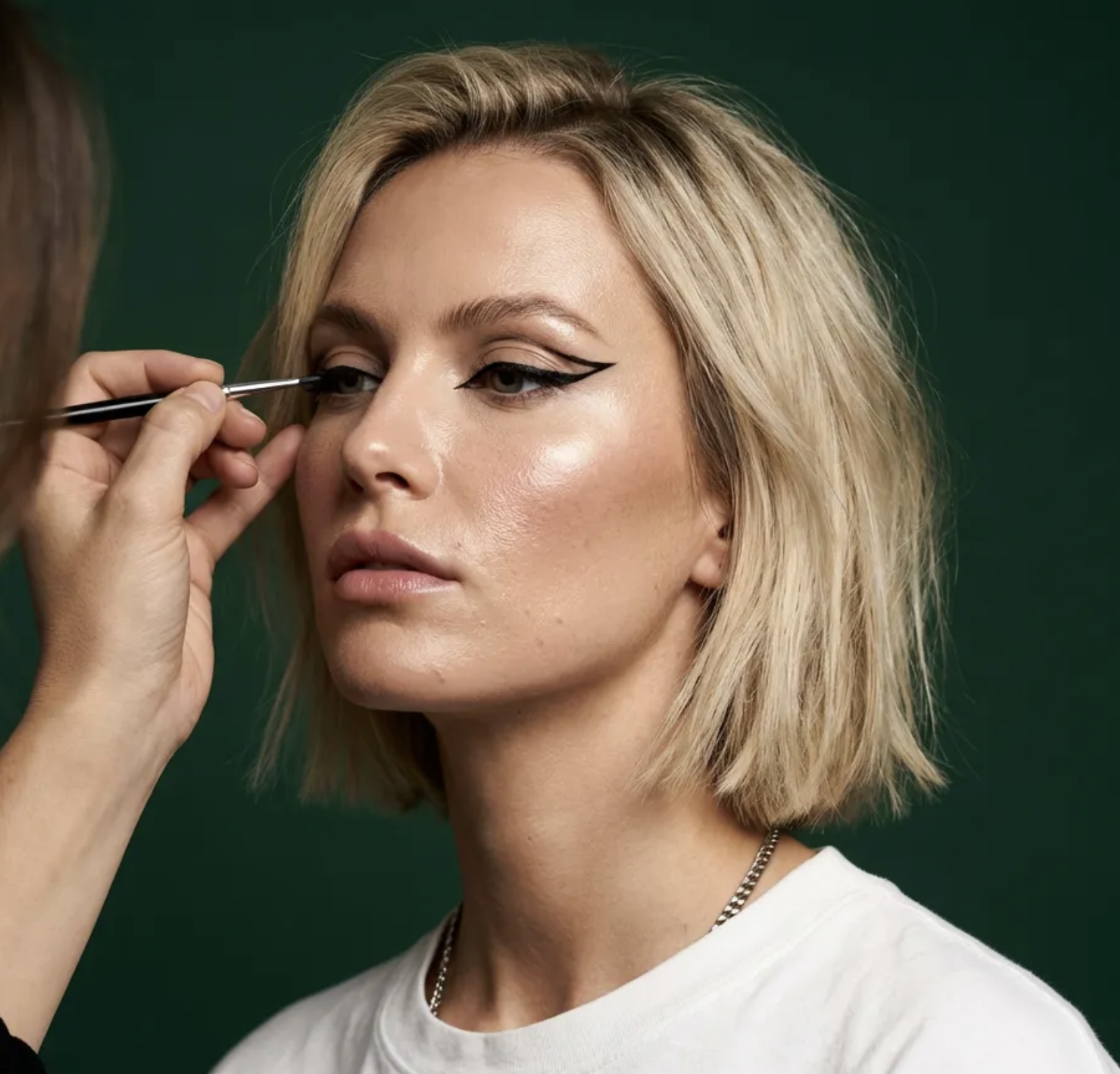 Makeup artist applying eyeliner on a client