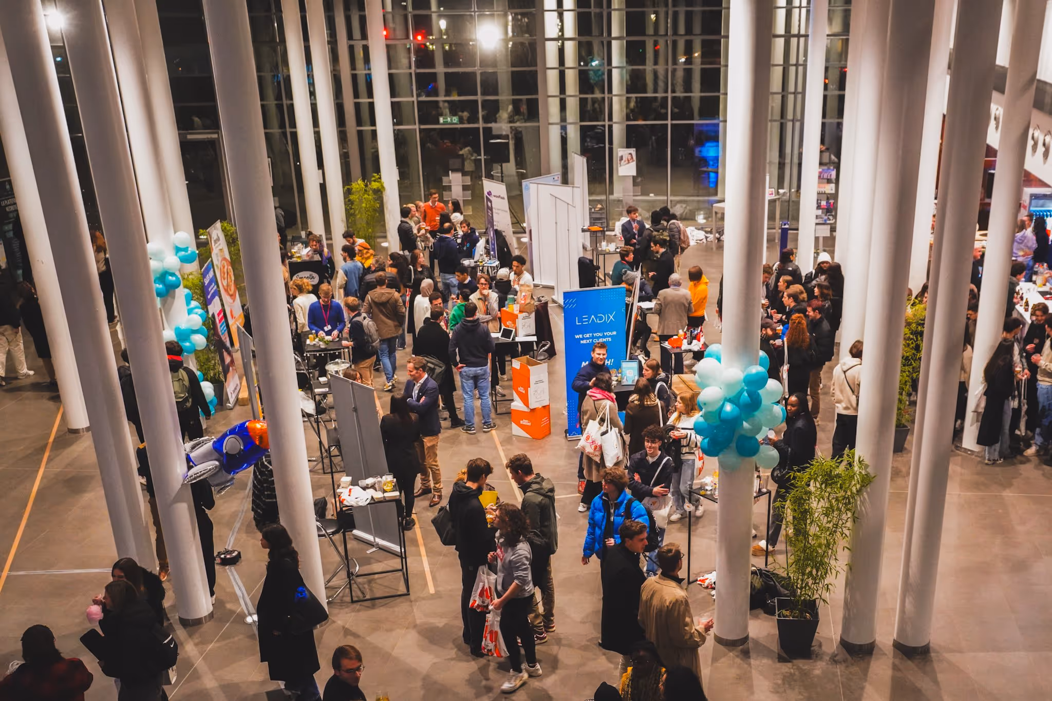 Événement Leadix avec des personnes et des ballons bleu-vert dans un grand hall