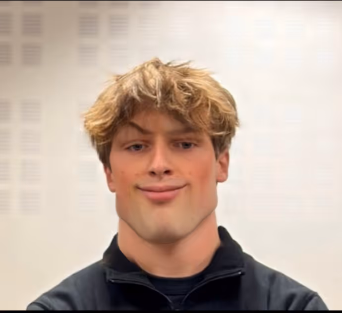 Jeune homme souriant aux cheveux bouclés portant une veste noire