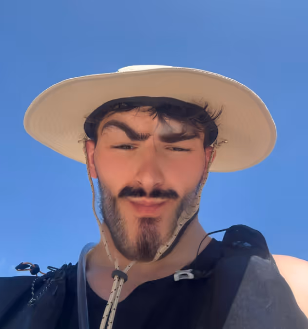Un homme avec un chapeau large sous un ciel bleu clair