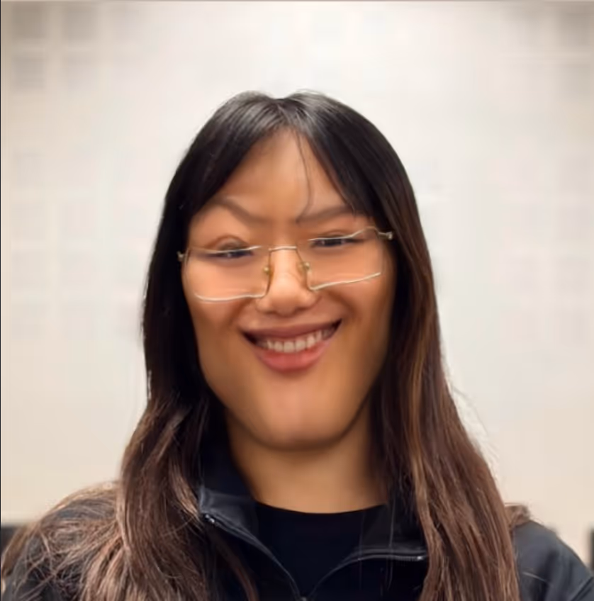 Femme souriante portant des lunettes et une veste noire