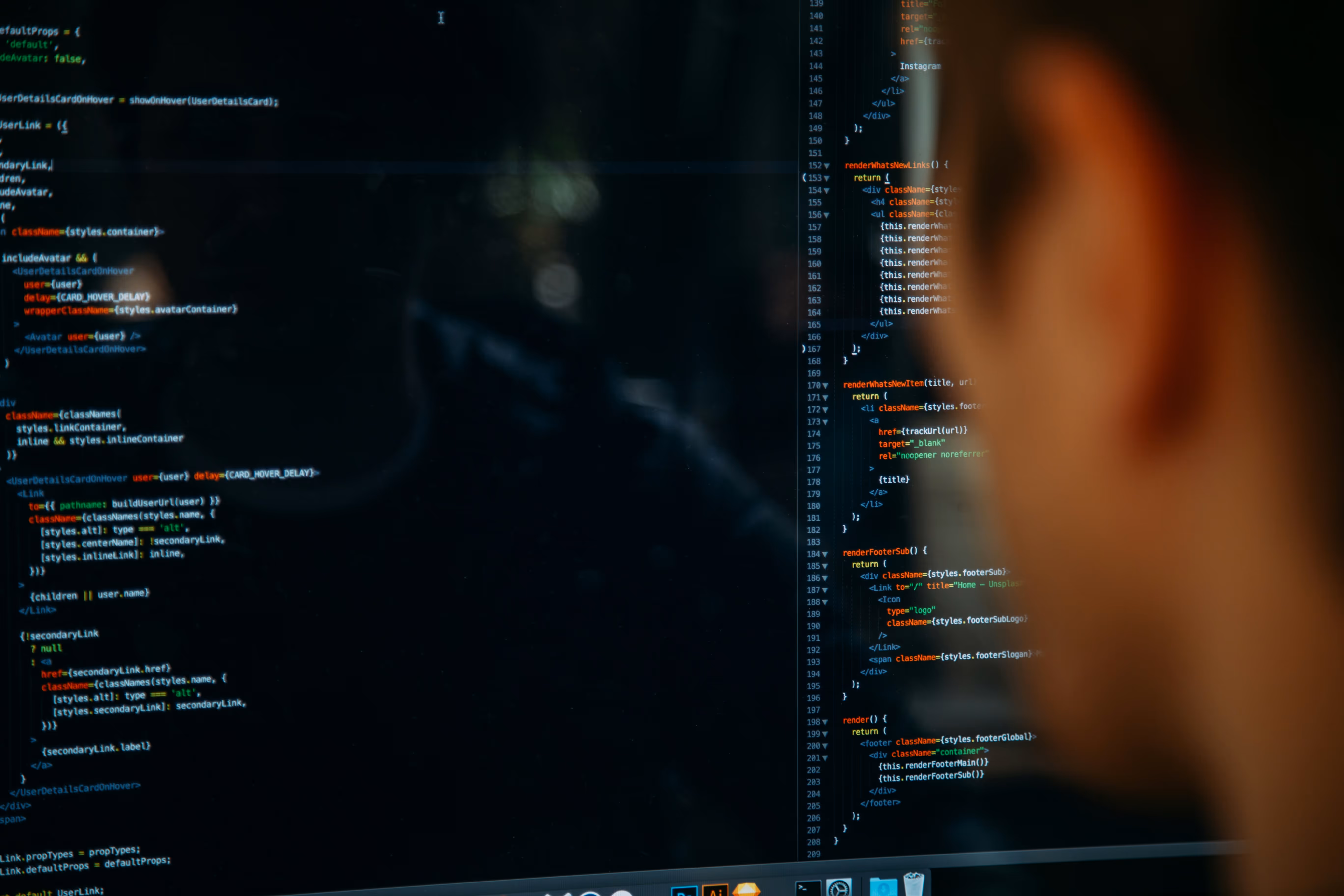Oseba gleda v računalniški zaslon z barvno programsko kodo v urejevalniku programskega jezika.