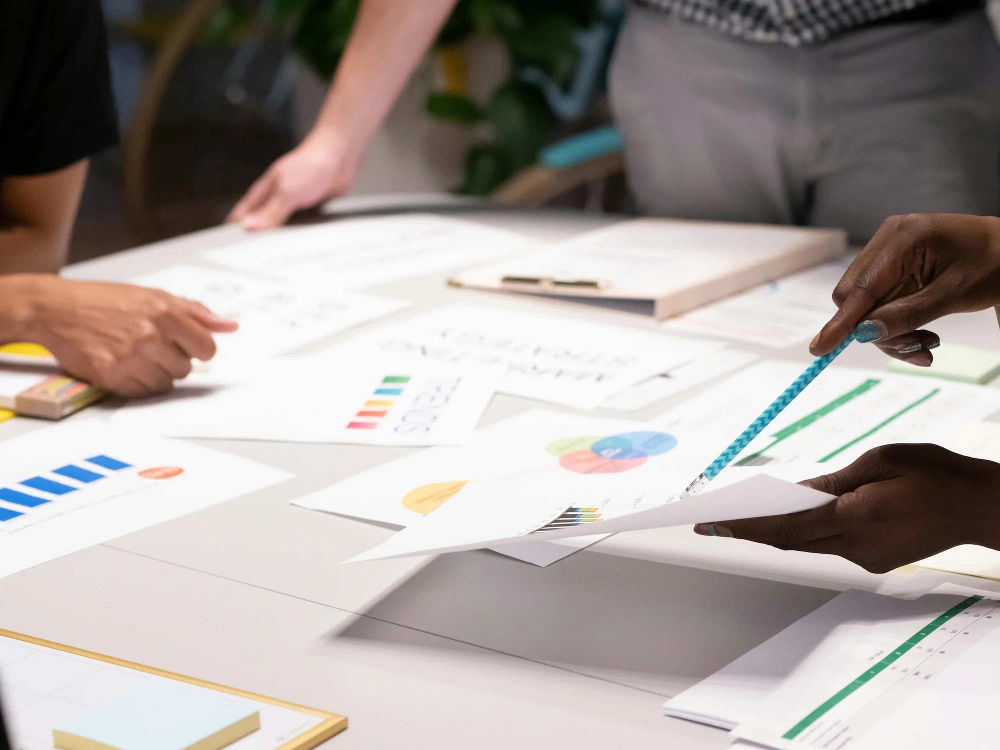 Ceramic pot with a glossy dark blue handle lid and abstract red wave design on a cream base, set against a colorful abstract background.