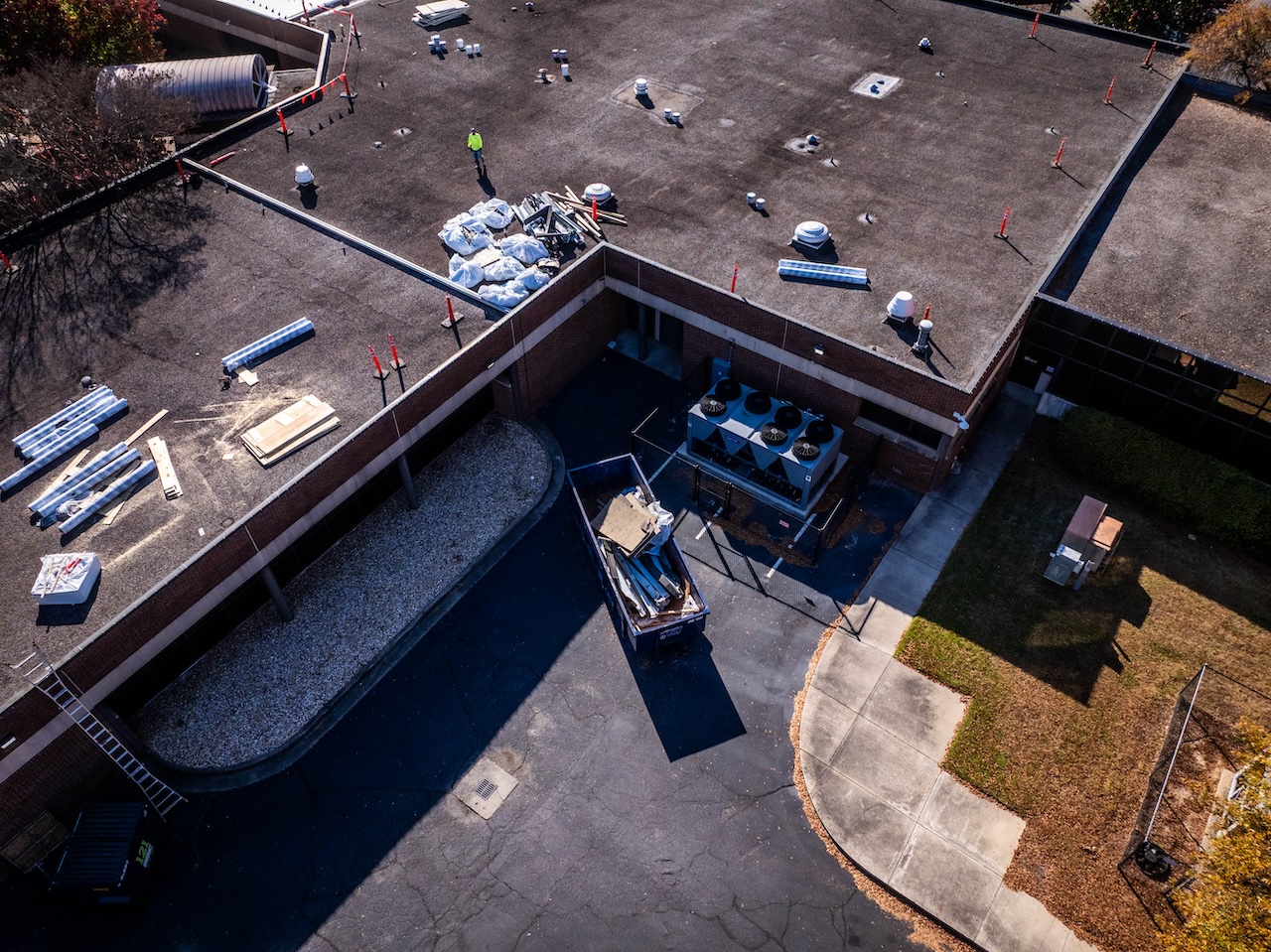 Aerial View Of Commercial Roof Renovation Dumpster