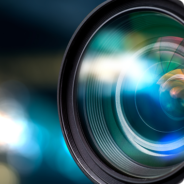 Close-up of a camera lens reflecting colorful light.