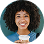 Smiling woman with curly hair holding a white cup.