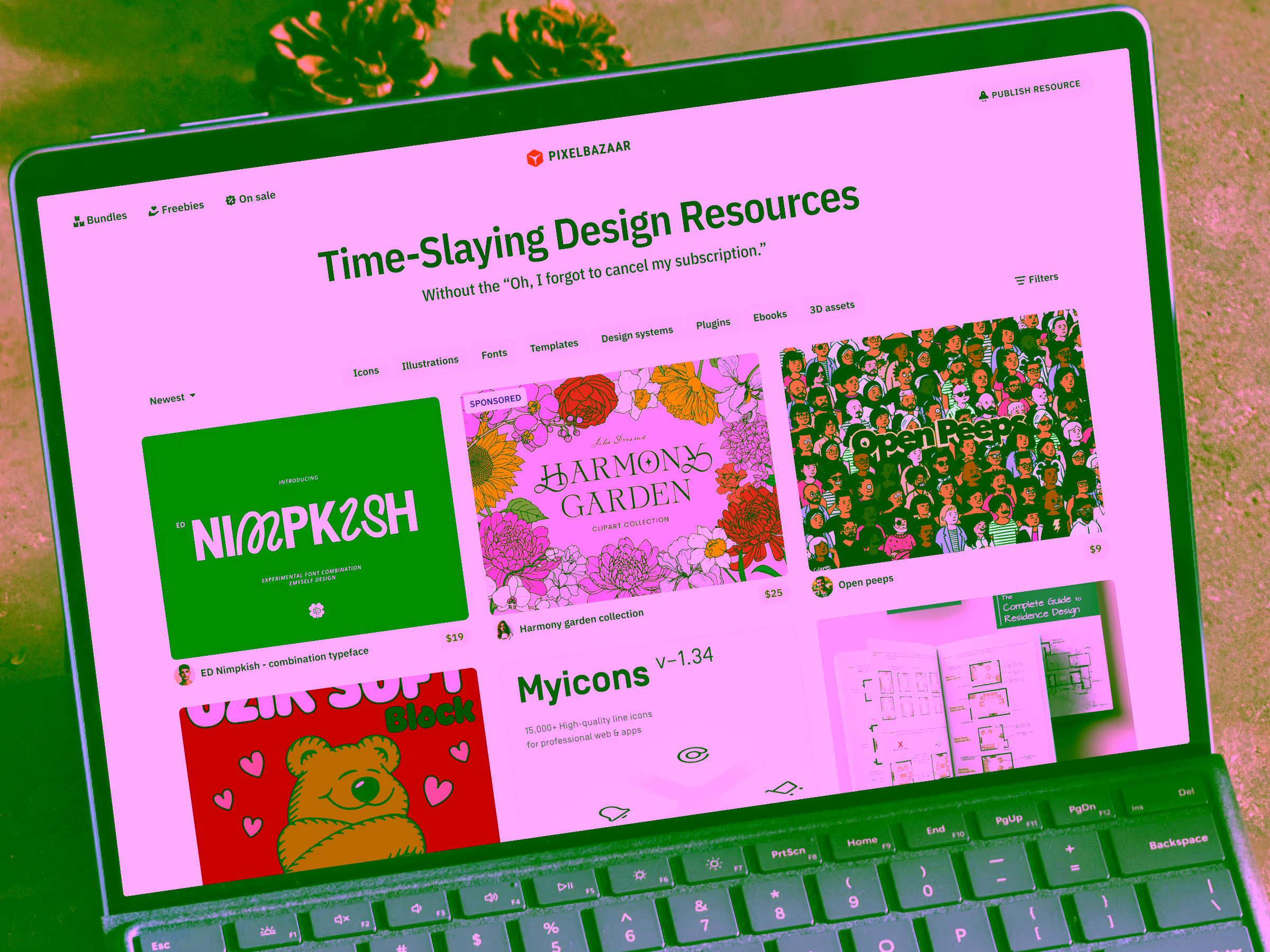 Laptop screen displaying Pixelbazaar website featuring design resources like fonts, clipart collection, and icons.