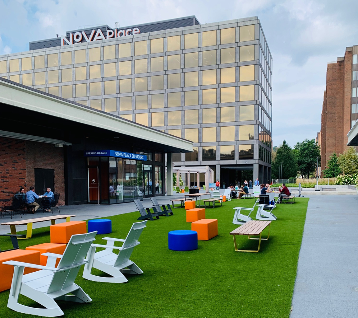 lawn chairs on green space outside of Nova Place building on campus