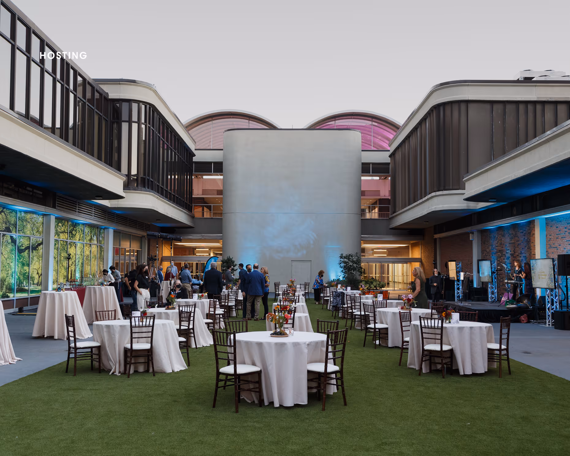 Outdoor common green space at Nova Place decorated with tables and chairs set up for formal event