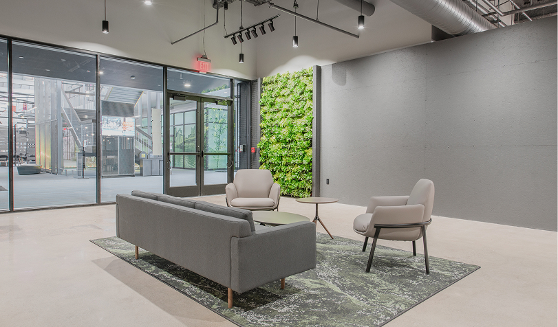 grey couch facing two off white chairs in spacious room at Nova Place