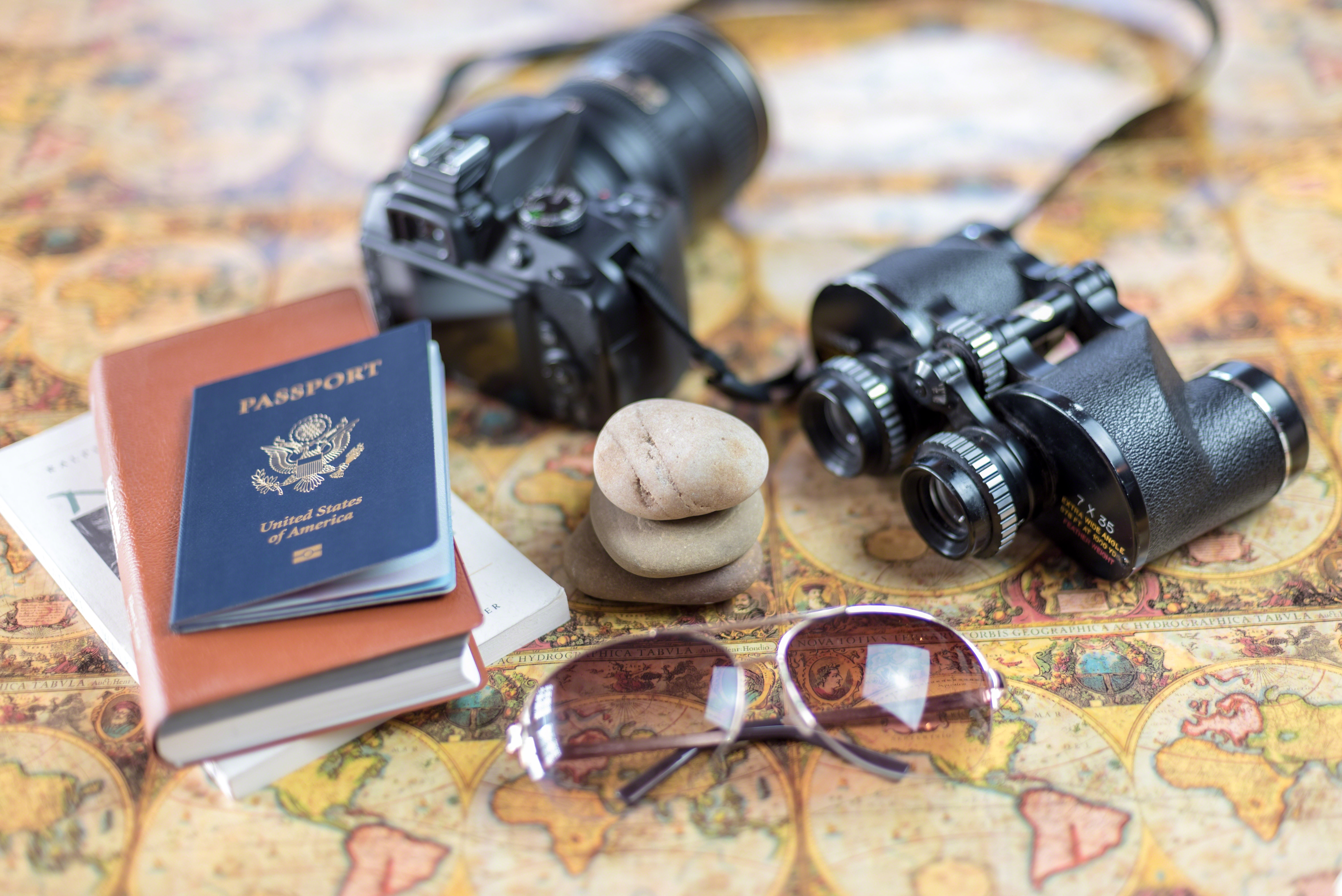 Flat lay of travel essentials for a St. John trip: hat, sunscreen, camera and map