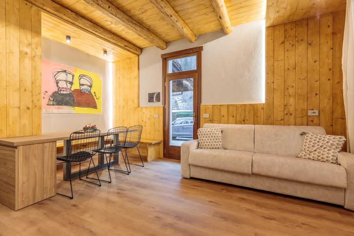 Renovierter Wohnbereich mit Holz und Sofa in einer Ferienwohnung in Courmayeur