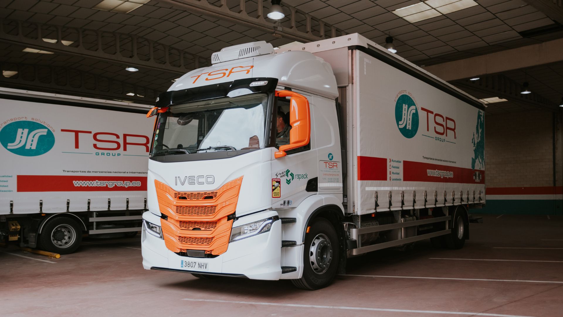 Camión IVECO S-Way de TSR Group con rotulación corporativa en el muelle de carga de las instalaciones