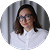 Smiling woman wearing glasses and a white blouse against a white background.