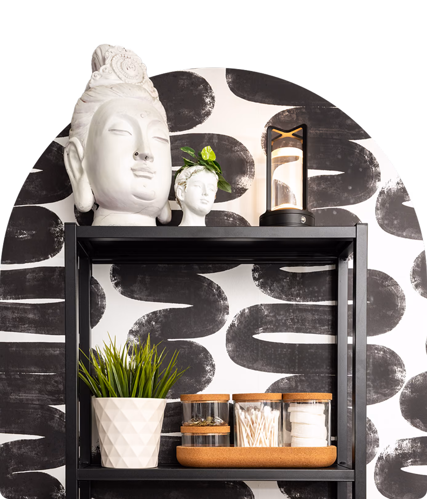 Black metal shelf with decorative busts, lamp, plant, and jars with cotton and swabs.
