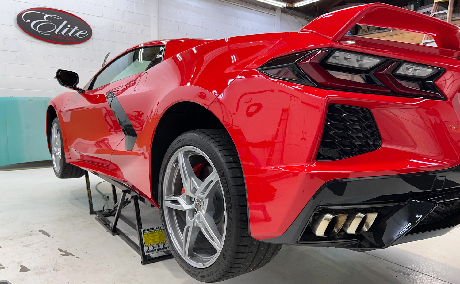 A red C8 Corvette on a stand in Elite Auto Spa in Auburn, CA