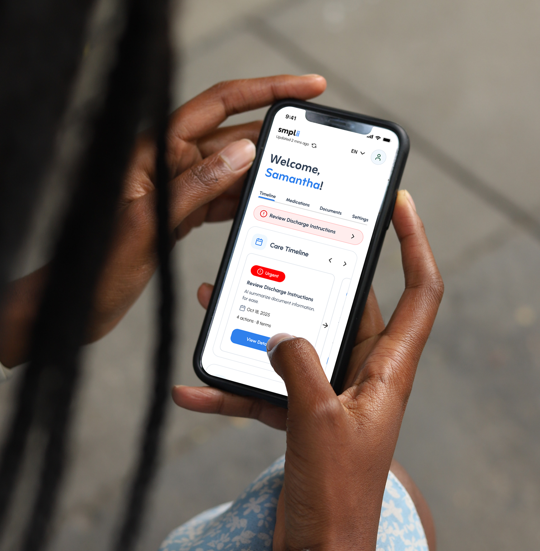 Person holding a smartphone displaying a healthcare app with a welcome message to Samantha and urgent notification to review discharge instructions.