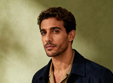 A man infront a gray background