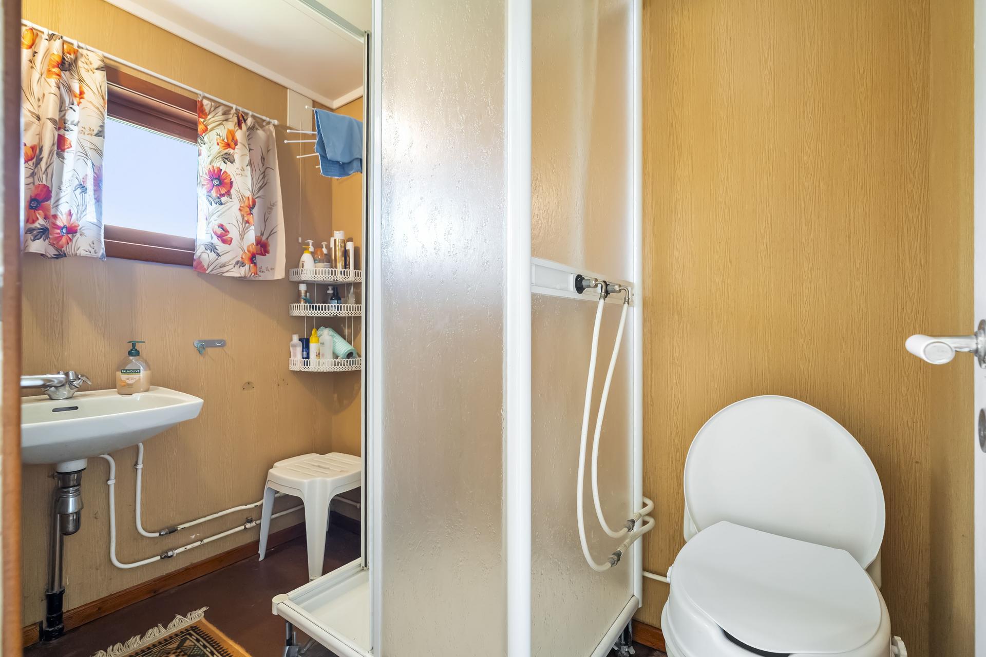 - Badet har malt betonggulv, tapet på veggene og malte takplater i taket. -