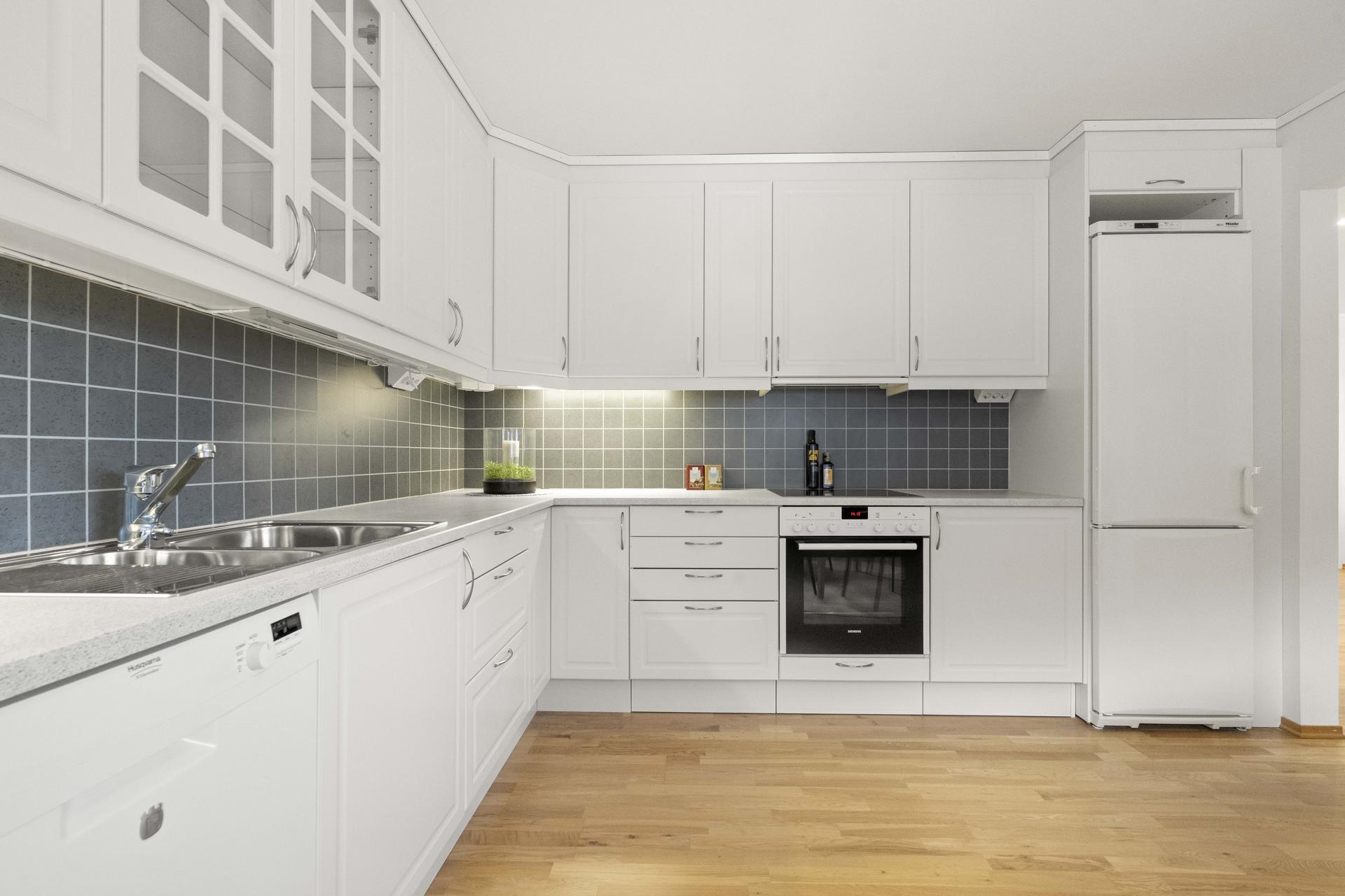 - Over benkeplaten er det montert kitchen board. Her er også belysning og praktisk stikkontakter i underkant av overskapene - 