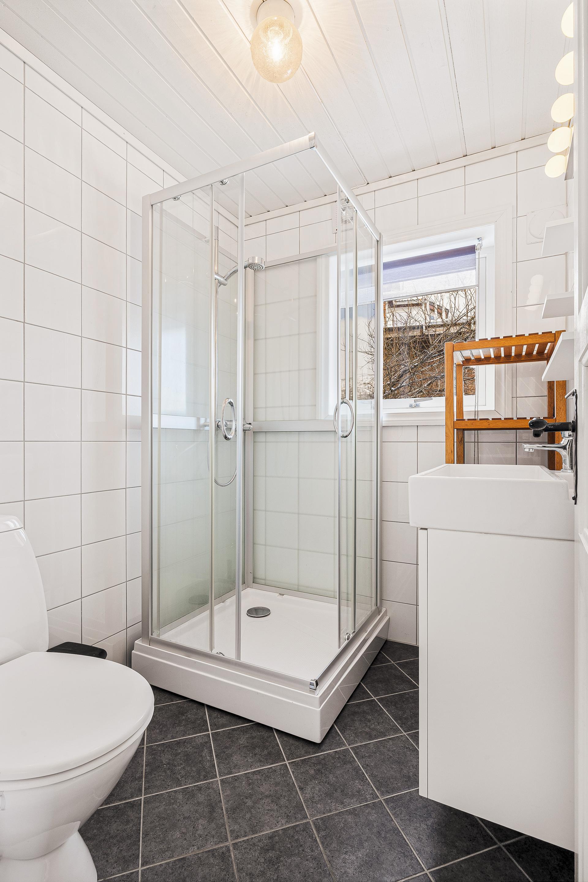 Badet inneholder bla servant, toalett, og dusjkabinett.