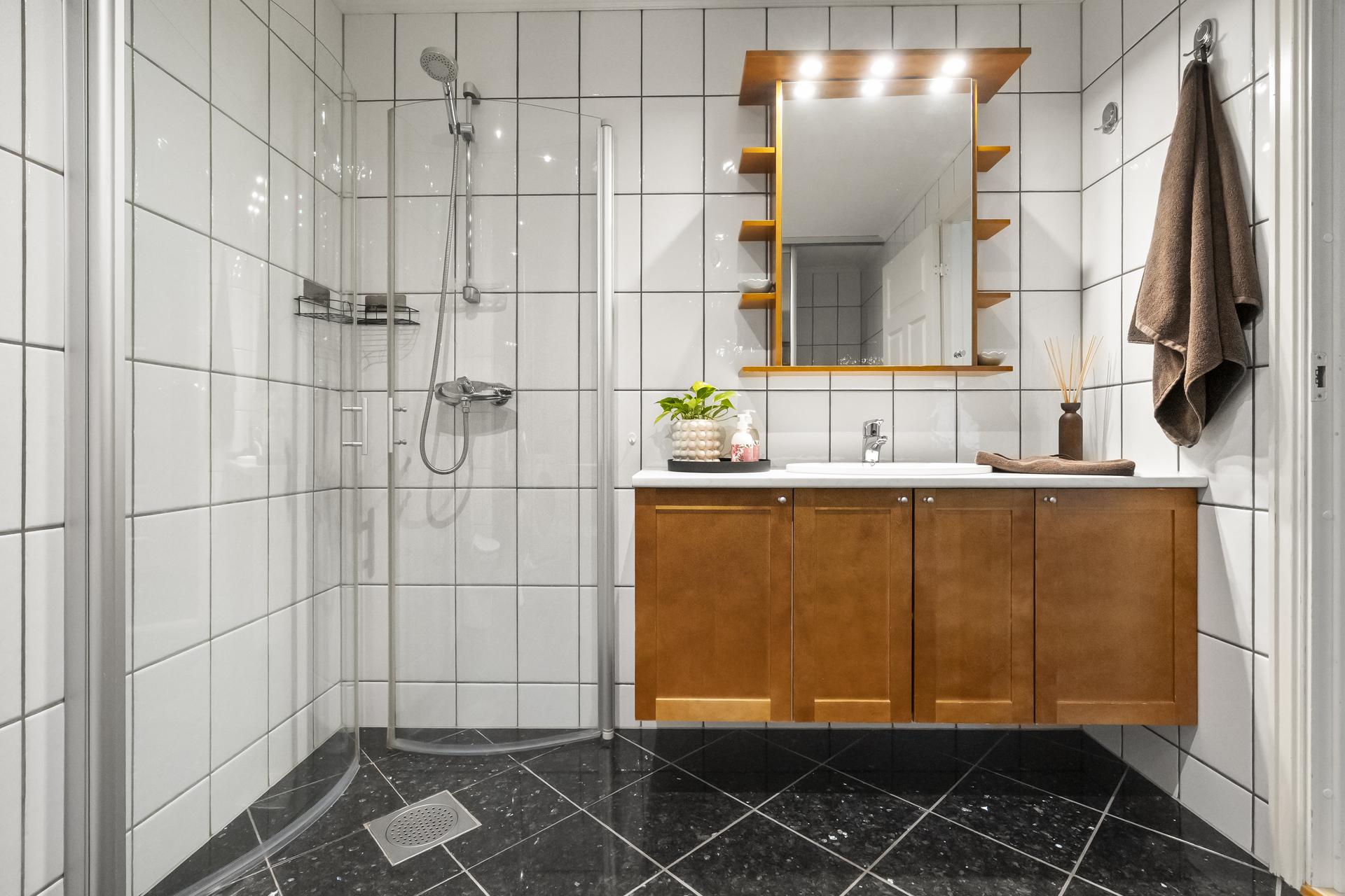 - Helfliset bad med varmekabler i gulv. Badet er innredet med dusjhjørne, baderomsinnredning med servant i underskap, toalett samt skyvedørsgarderobe med opplegg til vaskemaskin - 