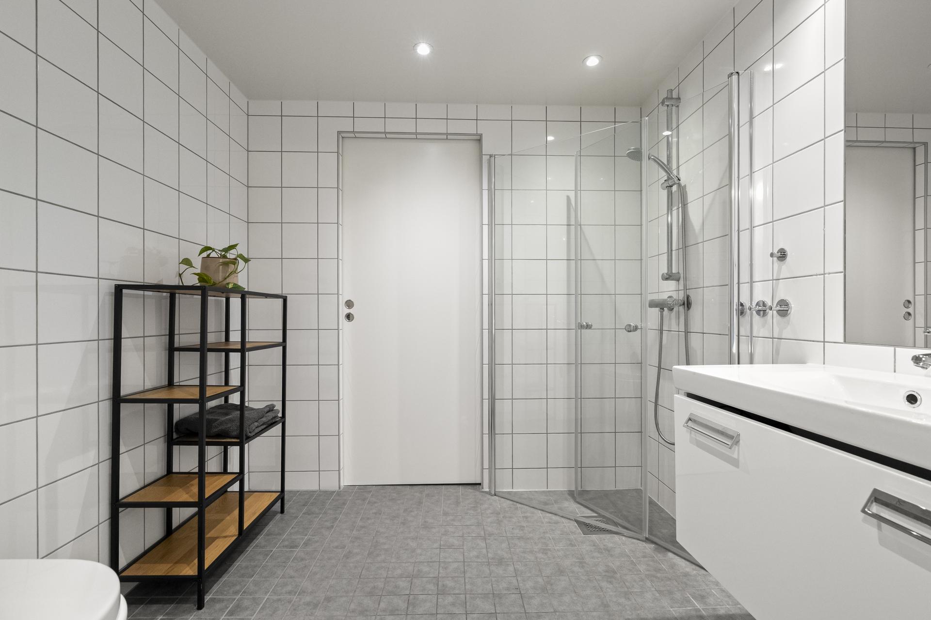 - Badet er innredet med vegghengt toalett, servant i underskap, speil og dusjhjørne. Det er også adskilt vaskerom med skyvedør fra bad - 