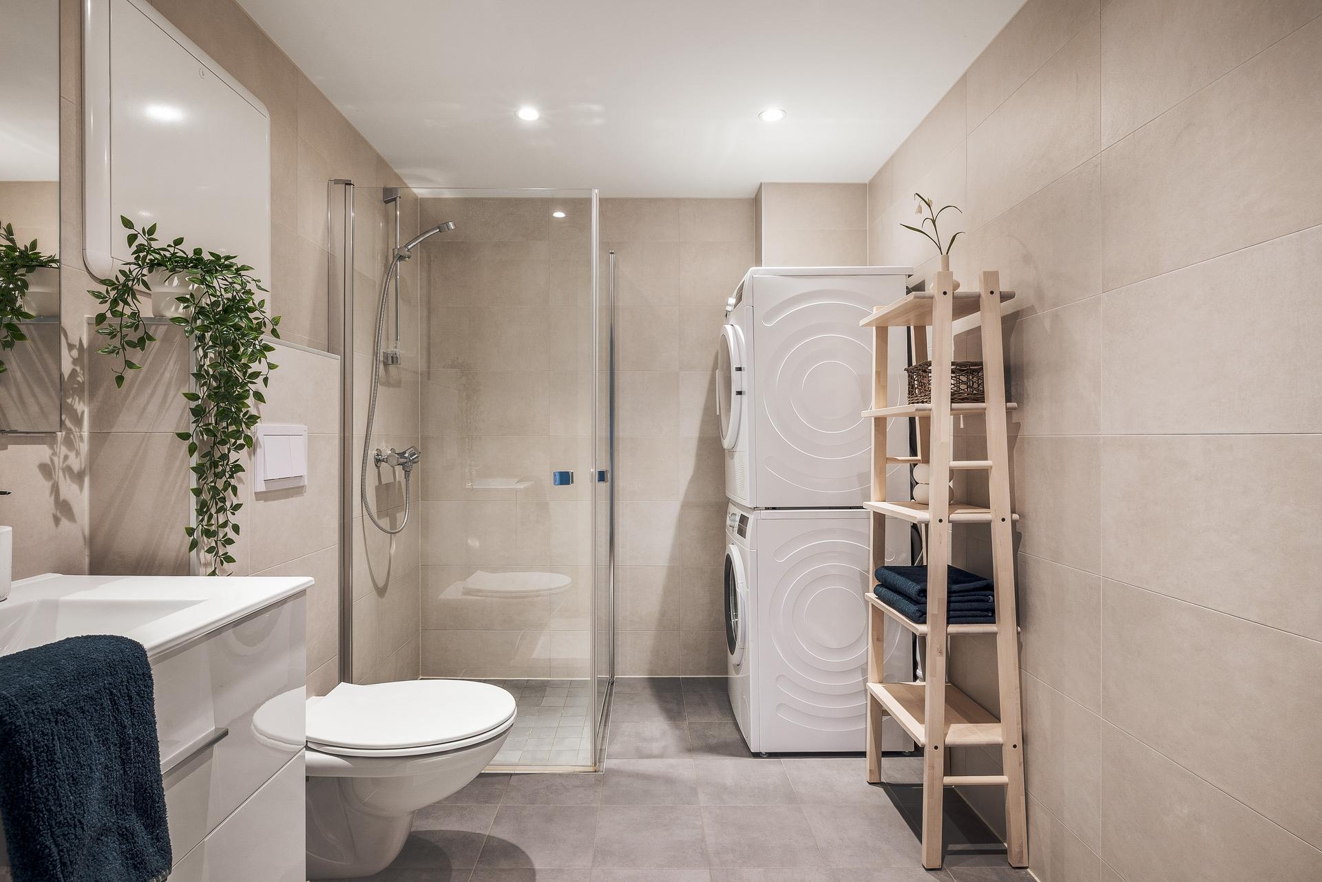 Badet er moderne utformet med fliser på både gulv og vegger, innfelte downlights og gulvvarme som gir ekstra komfort. Her får du en funksjonell hverdagsluksus med det lille ekstra.