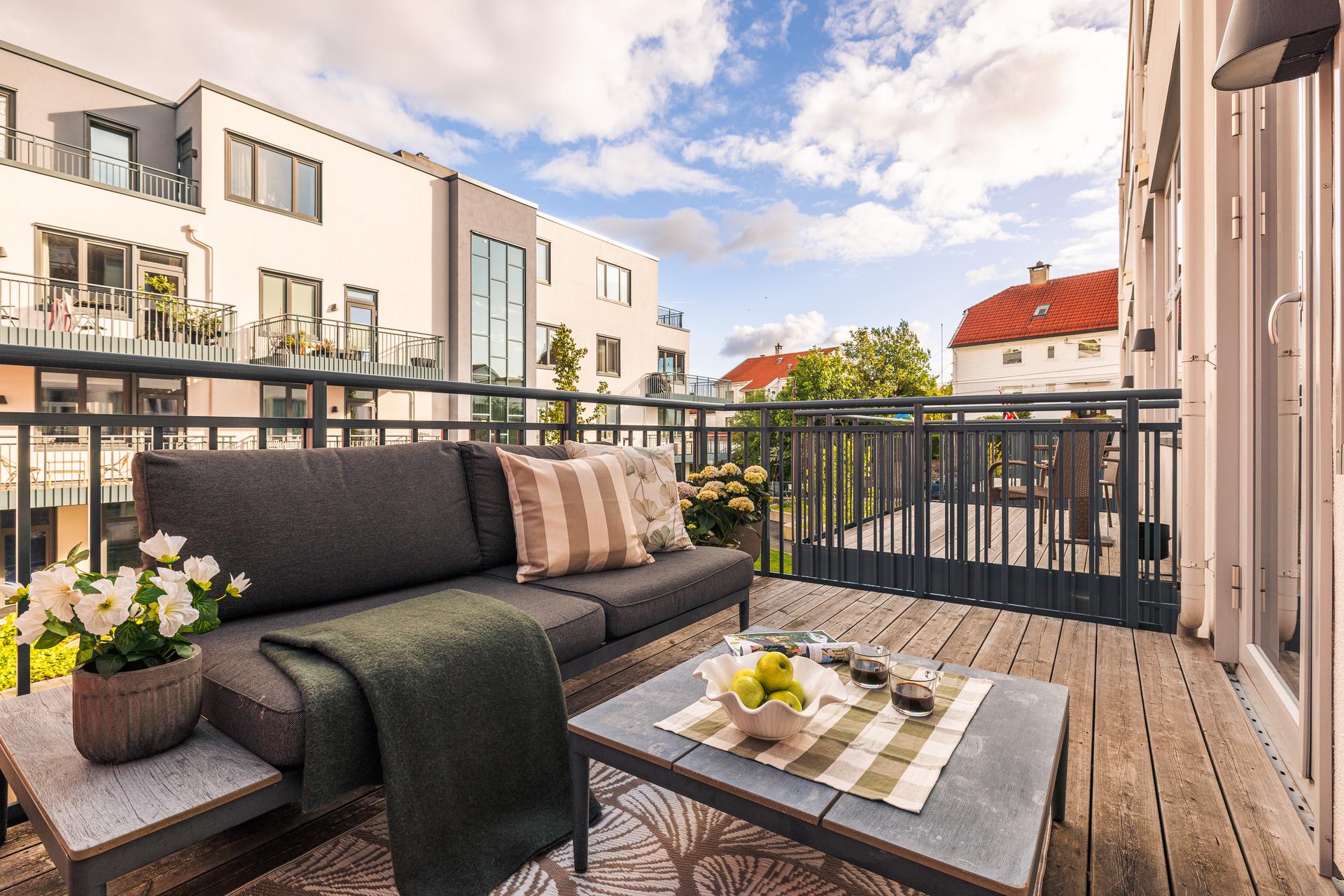 Fra balkongen har du flott utsyn til sameiets velstelte uteområder, med grønne plener, steinheller, sittegrupper og beplantning. Dette gir en luftig og harmonisk atmosfære når man nyter en flott sommerdag. 
