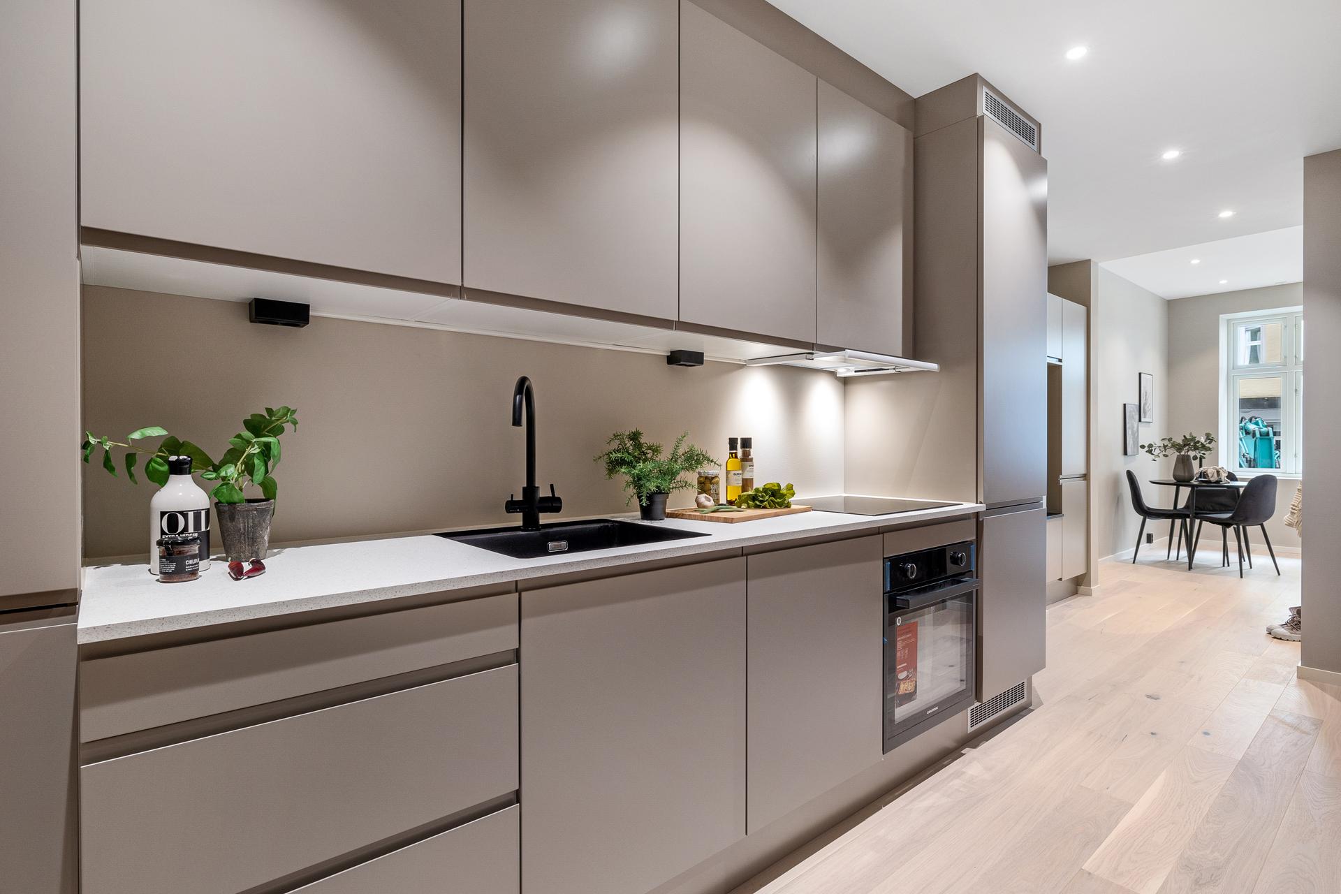 Kjøkkenet er en naturlig del av oppholdsrommet og kombinerer funksjonalitet med moderne design på en elegant måte.