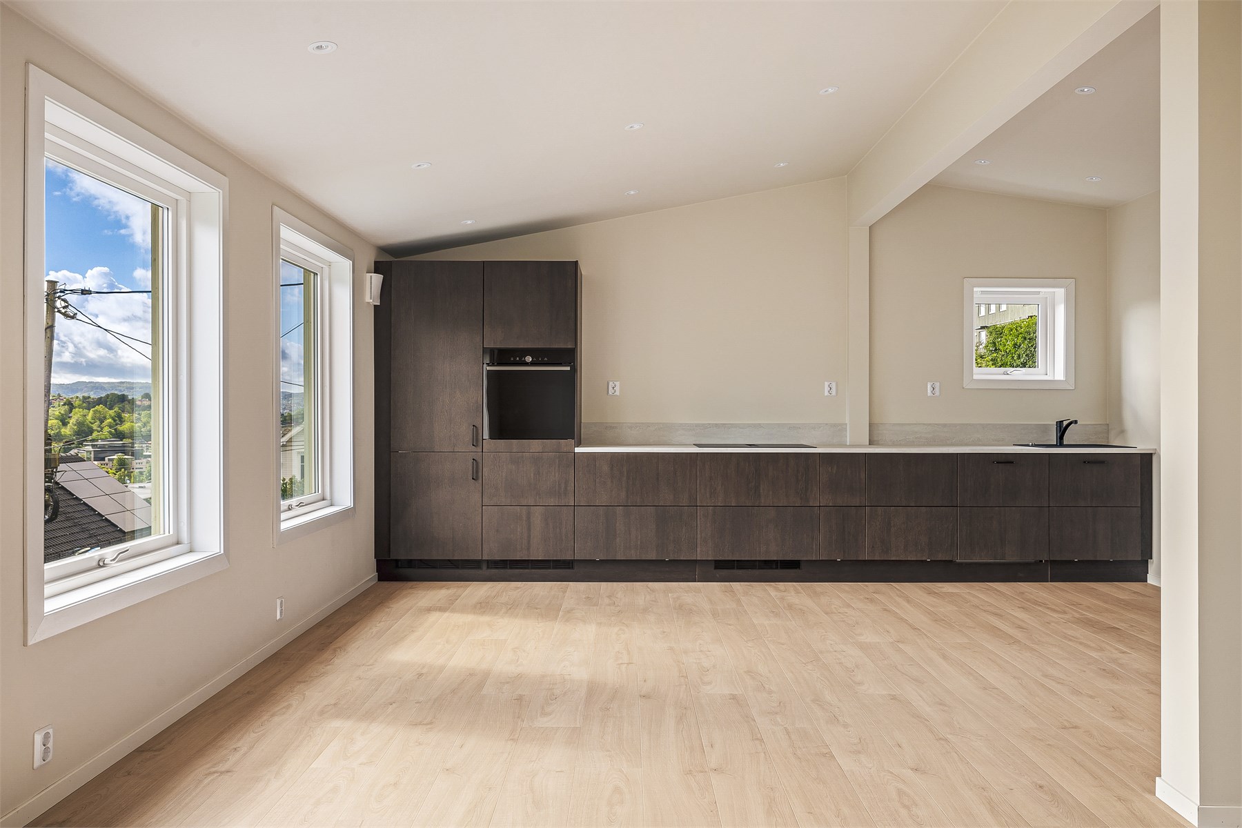 Kjøkkenet er en naturlig del av oppholdsrommet og kombinerer funksjonalitet med moderne design på en elegant måte.