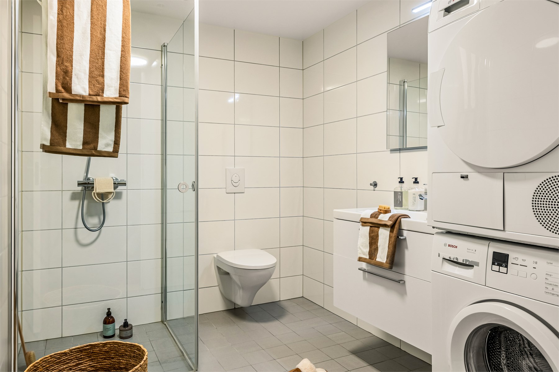 Badet er moderne og funksjonelt, med opplegg for vaskemaskin og tørketrommel.