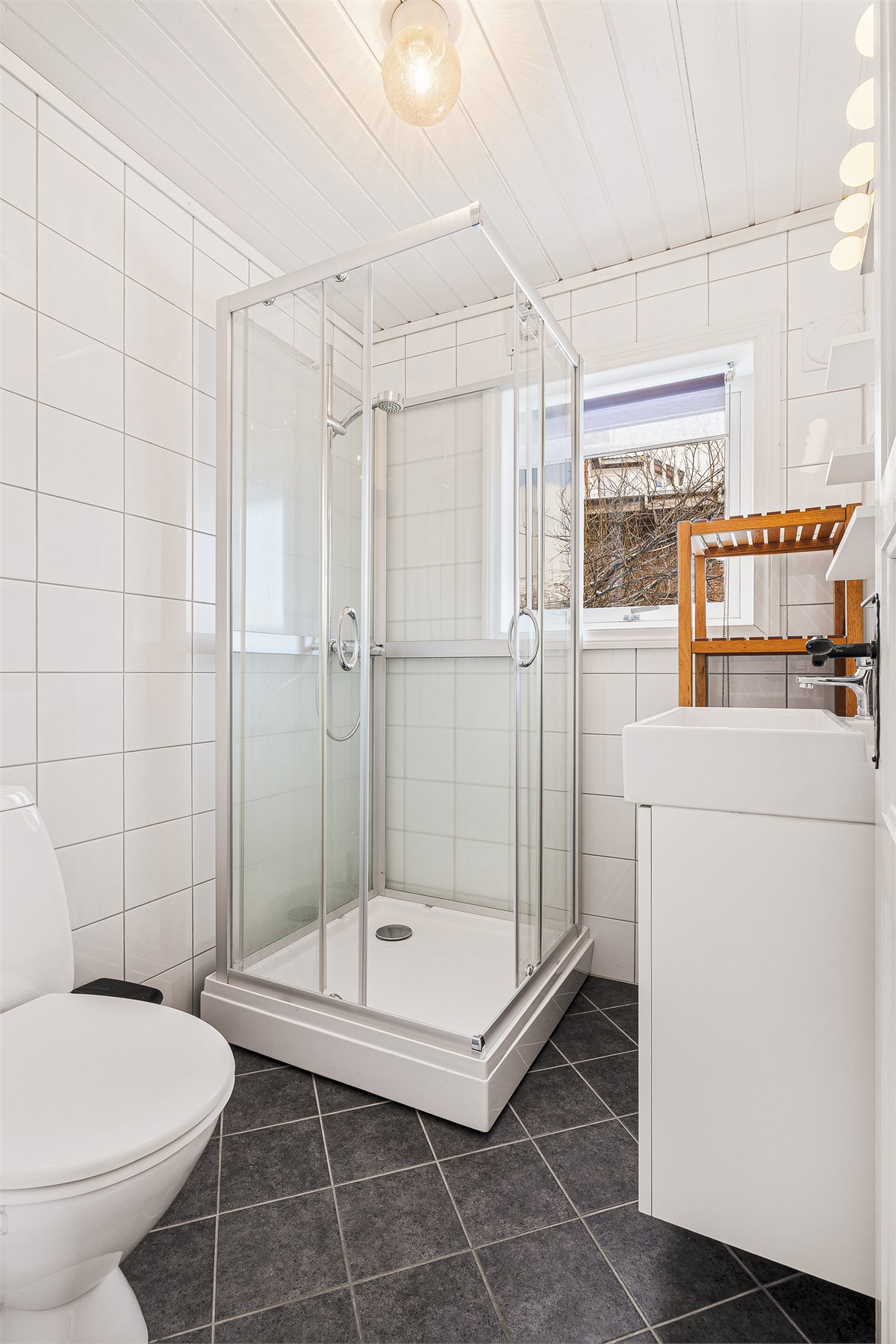 Badet inneholder bla servant, toalett, og dusjkabinett.