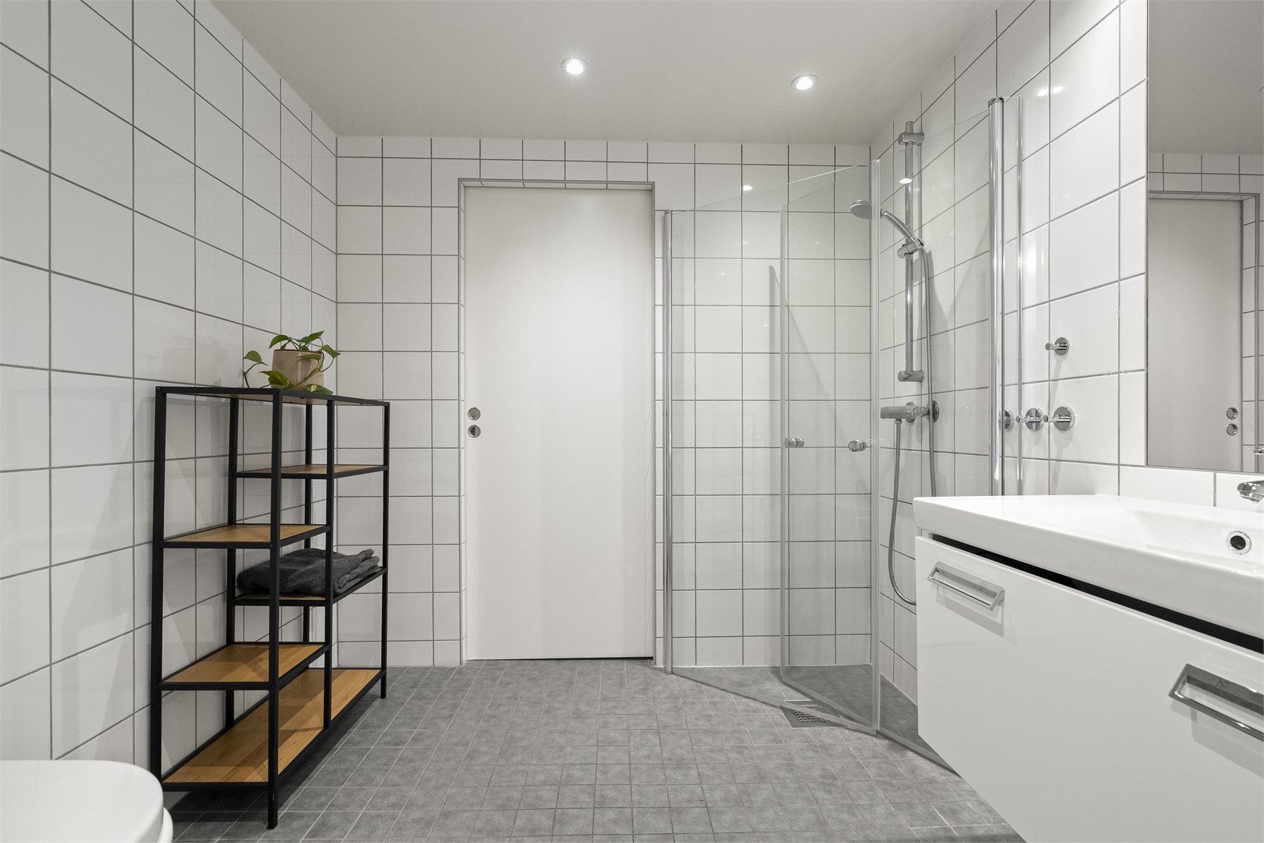 - Badet er innredet med vegghengt toalett, servant i underskap, speil og dusjhjørne. Det er også adskilt vaskerom med skyvedør fra bad - 