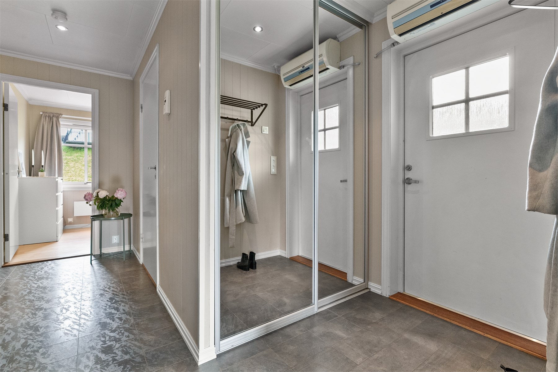 - Entrè har fliser på gulv og praktisk skyvedørsgarderobe med speil - 