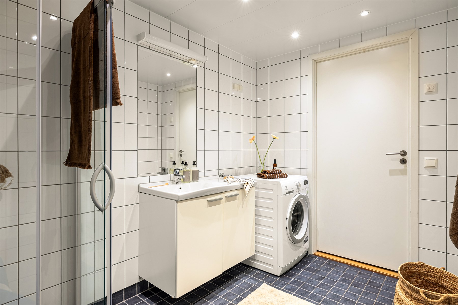 Romslig bad på med flislagte gulv og vegger, varmekabler i gulvet og eget opplegg for vaskemaskin.