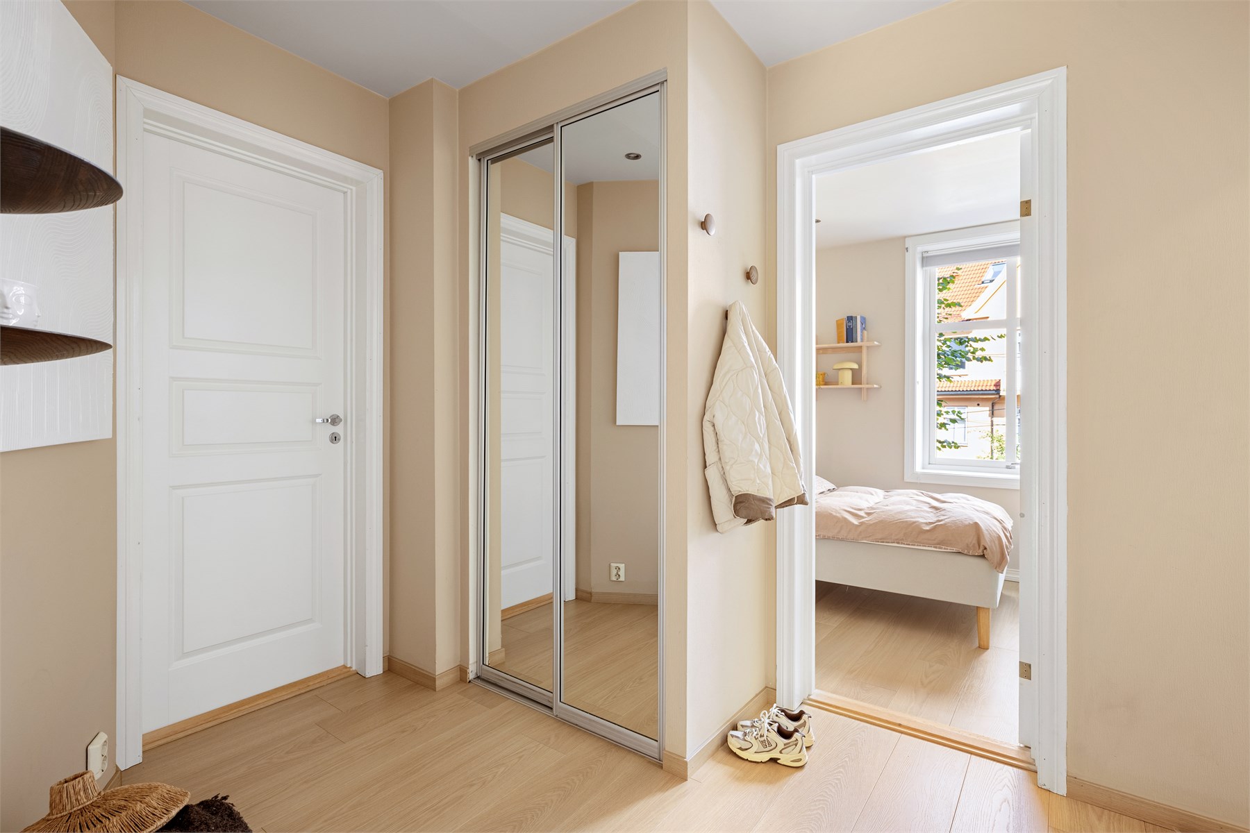 I entréen er det godt tilrettelagt for oppbevaring av yttertøy og sko, med en integrert skyvedørsgarderobe med speilfronter som både er praktisk og bidrar til en fin romfølelse.