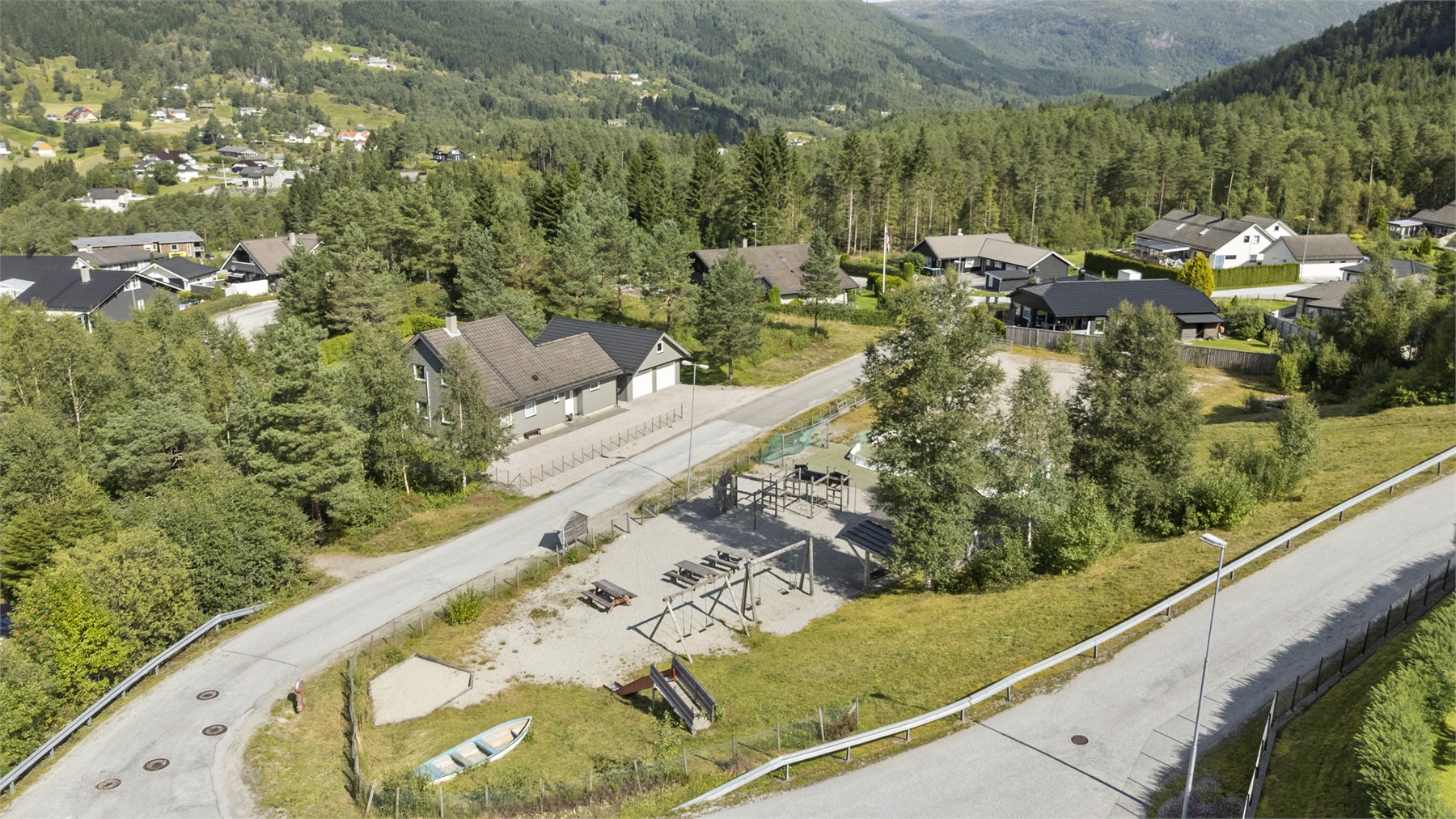 - Like ved boligen er det lekeplass med ballbane og lekestativ - 