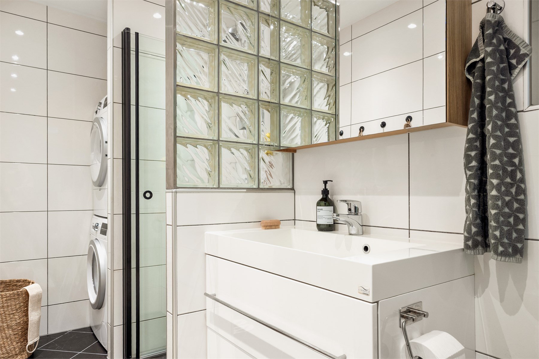 Badet har en praktisk utforming med plass til både vaskemaskin og tørketrommel. 