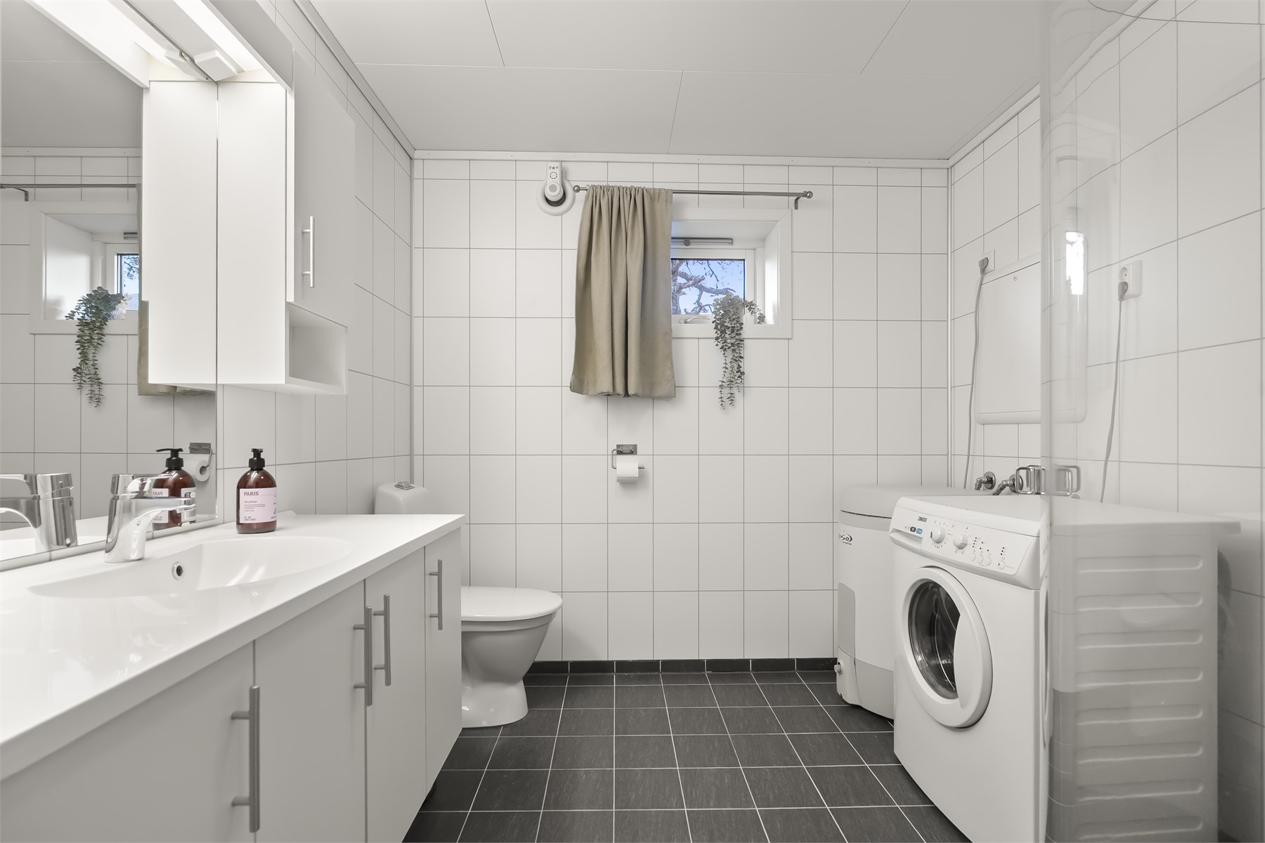 - Badet har flislagt gulv med varmekabler og plater på vegg. Her er også opplegg til vaskemaskin - denne medfølger handelen - 