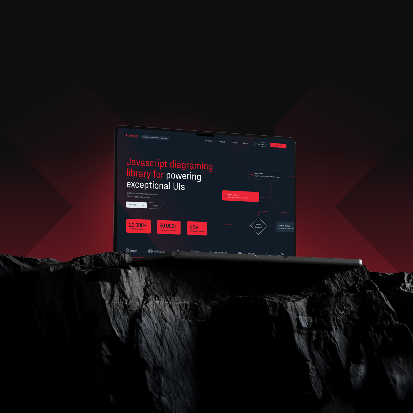 Laptop on dark rocky surface displaying a JavaScript diagramming library homepage with red and white text on a dark background.