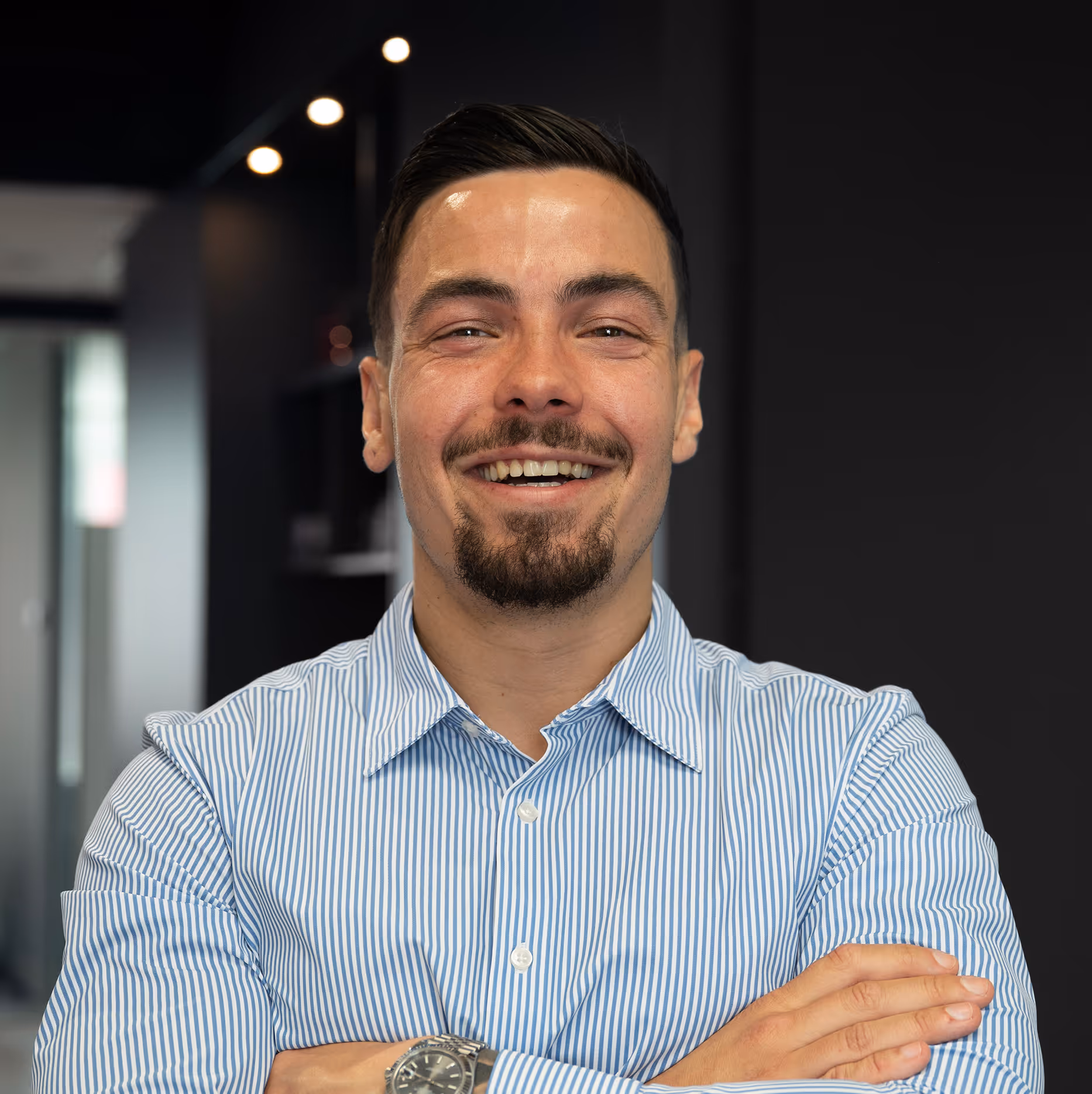 Mitchel van TopClicks. Lachende man met baard en snor, met opgestoken armen en een blauw-wit gestreept overhemd.