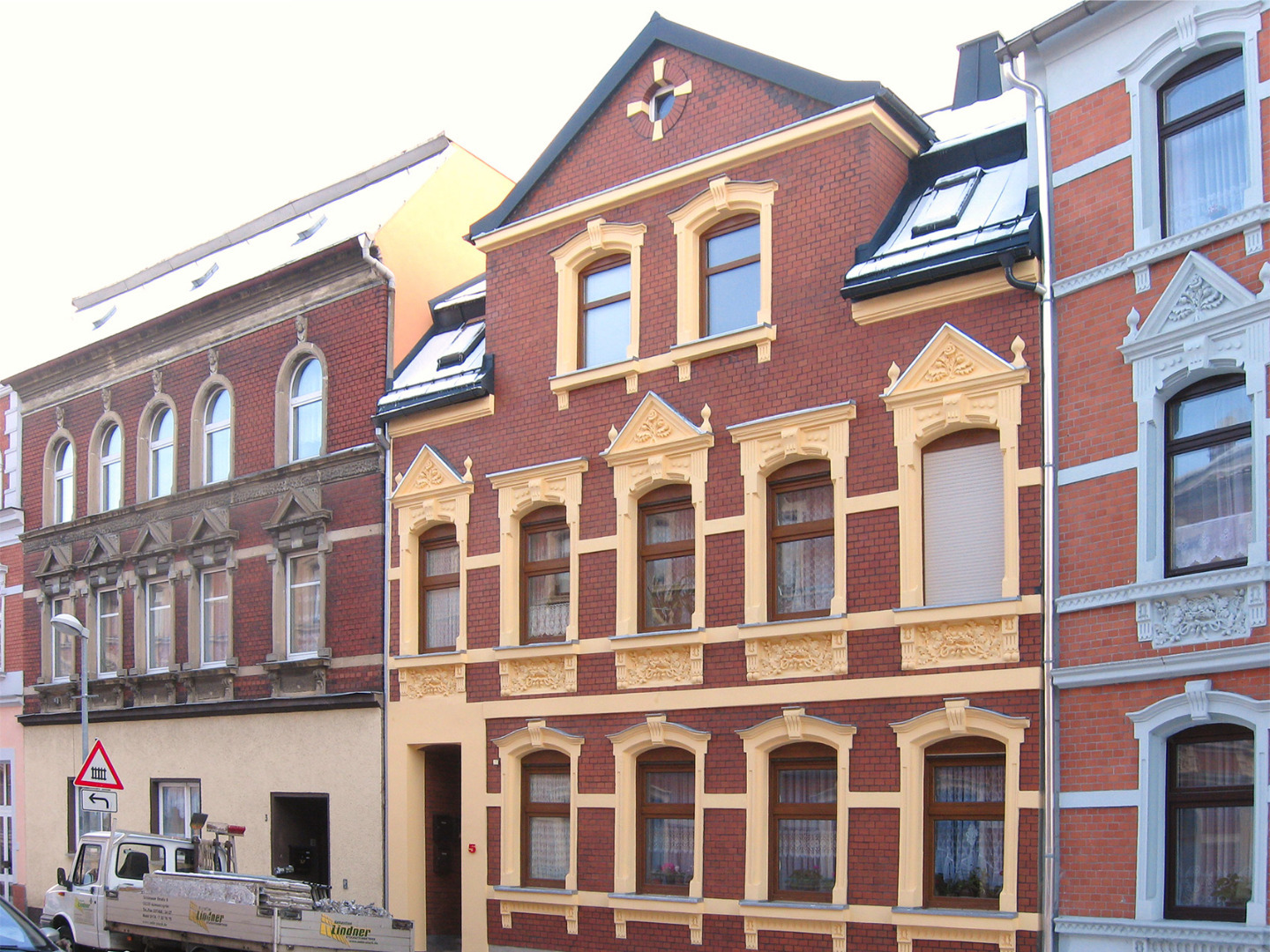 Fachgerechte Aufarbeitung einer historischen Fassade mit Klinker-Elementen und Stuckverzierungen.