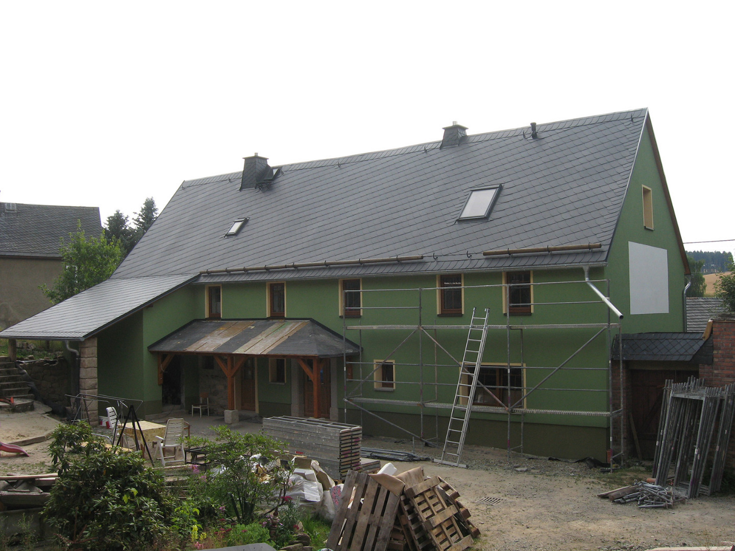 Laufende Sanierungsarbeiten an einem großen Gebäude. Die Außenwanddämmung wird gerade installiert, bevor der Oberputz aufgetragen wird.