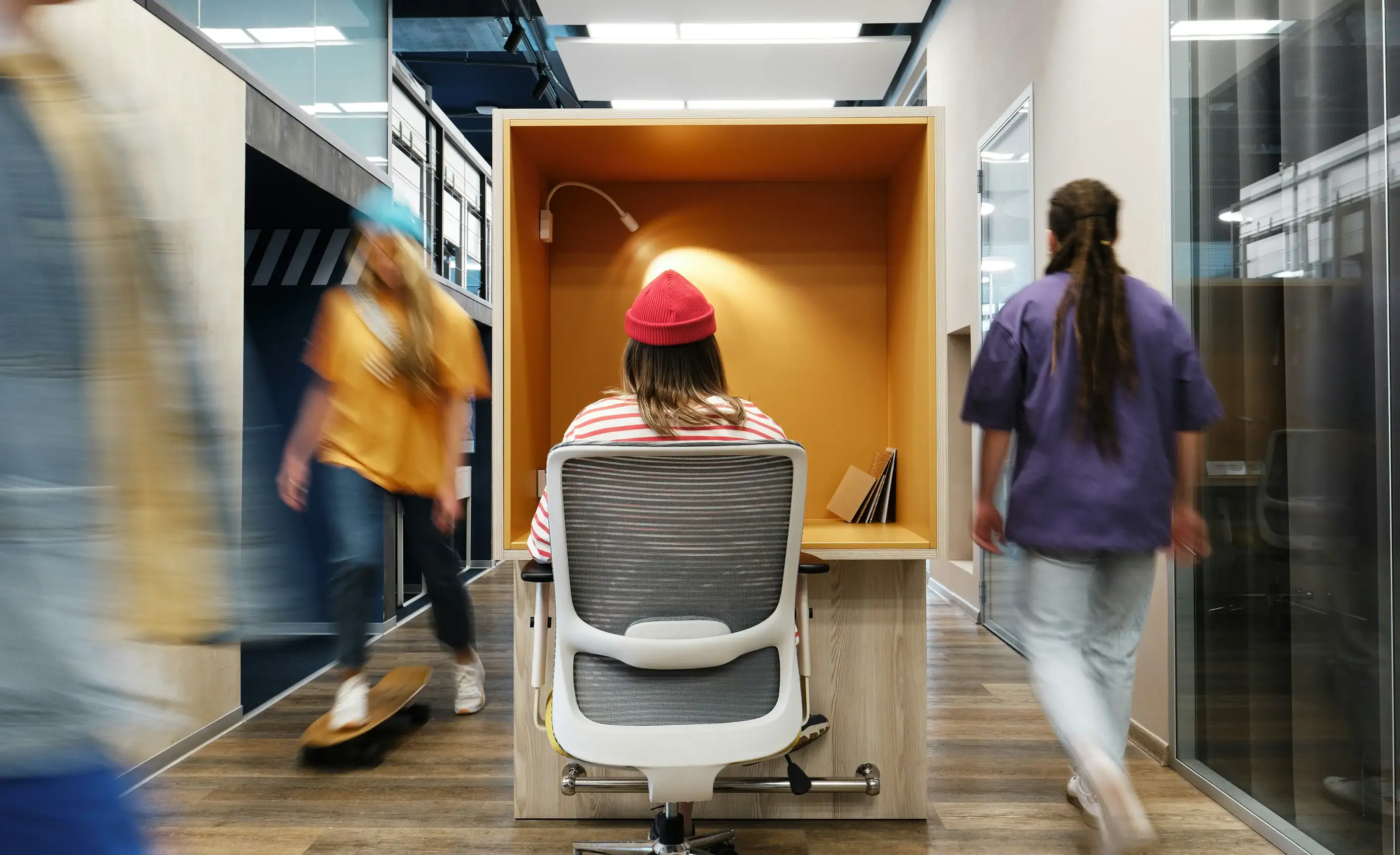 Growth consultant and branding agency workplace with background blur and employee working in small desk with red hat